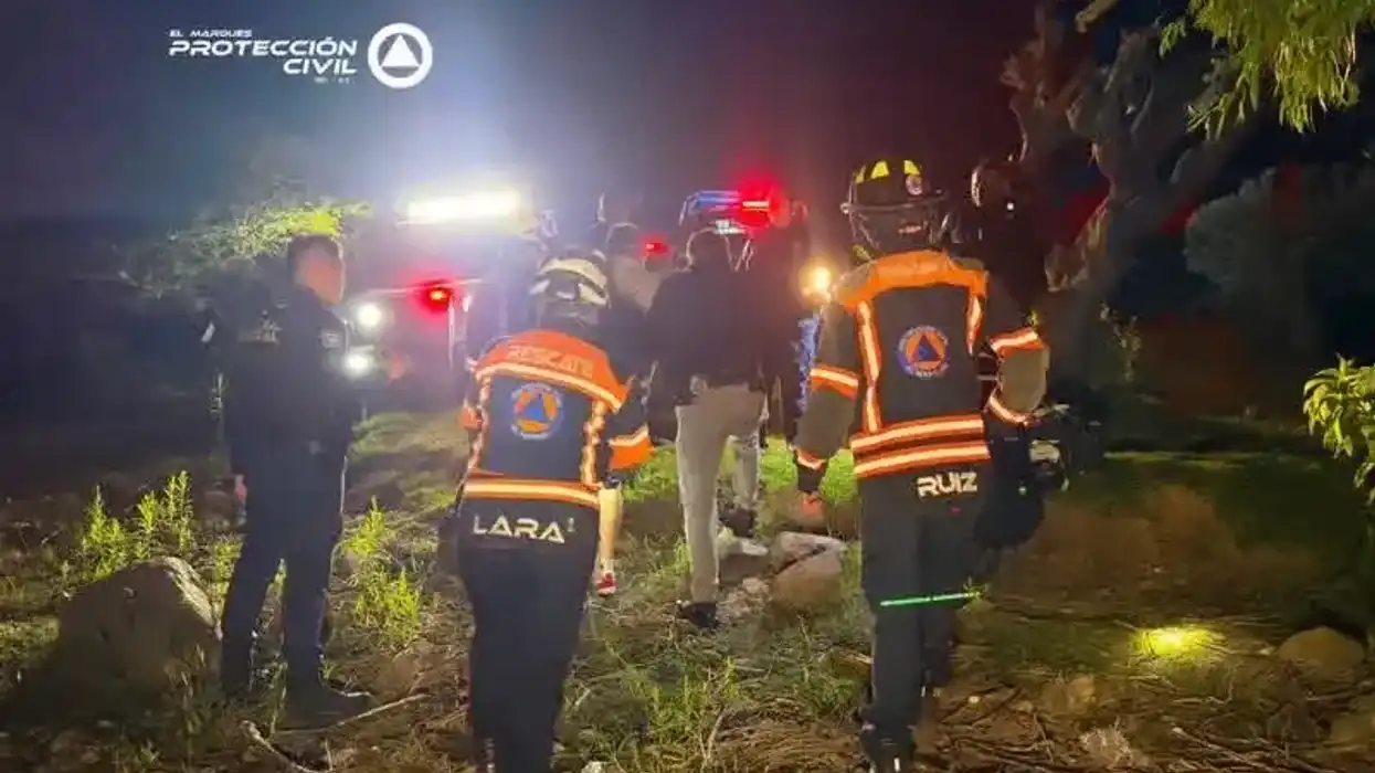 Rescatista de Protección Civil El Marqués atiende a una de las dos personas rescatadas tras caer un vehículo a la presa del Carmen durante la noche del 20 de julio de 2026.
