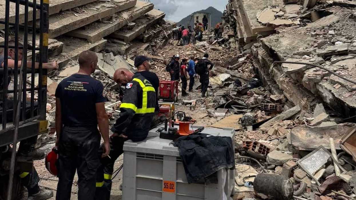 Rescatistas con equipo de búsqueda trabajan entre los escombros de edificios colapsados en La Guaira, Venezuela.