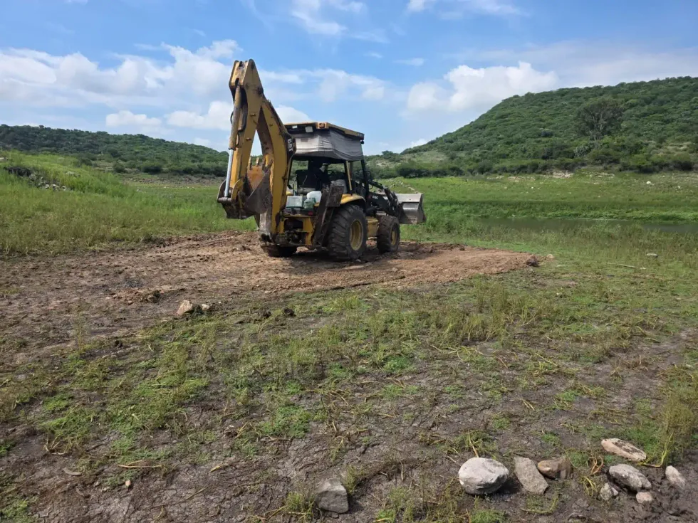 Retroexcavadora sobre terreno despejado junto a la presa El Bat\u00e1n, en Corregidora.