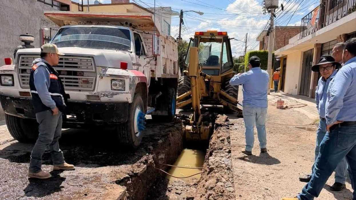 Retroexcavadora y camión de volteo en zanja para renovar drenaje en calle Constituyentes, San Juan del Río