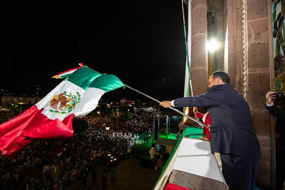 Roberto Cabrera Valencia agita la bandera nacional desde el balc\u00f3n del Templo de Nuestra Se\u00f1ora de Guadalupe durante el Grito de Independencia en San Juan del R\u00edo.