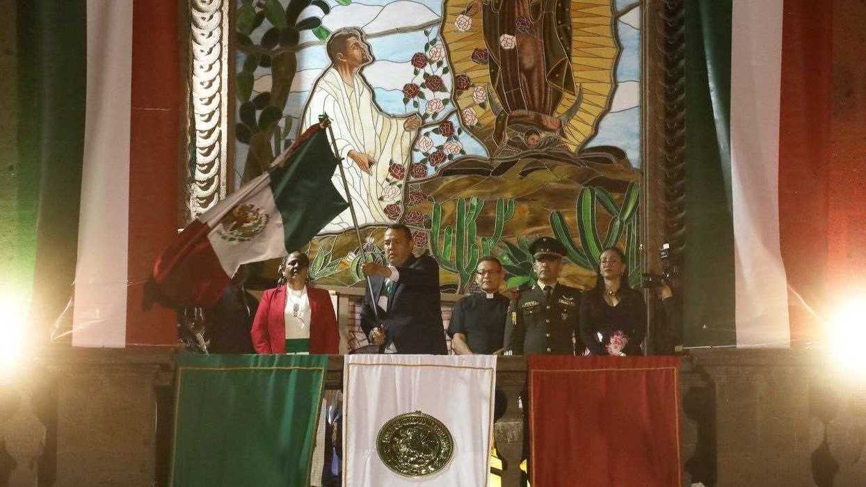 Roberto Cabrera Valencia agita la bandera nacional desde el balcón del Templo de Nuestra Señora de Guadalupe durante el Grito de Independencia en San Juan del Río.