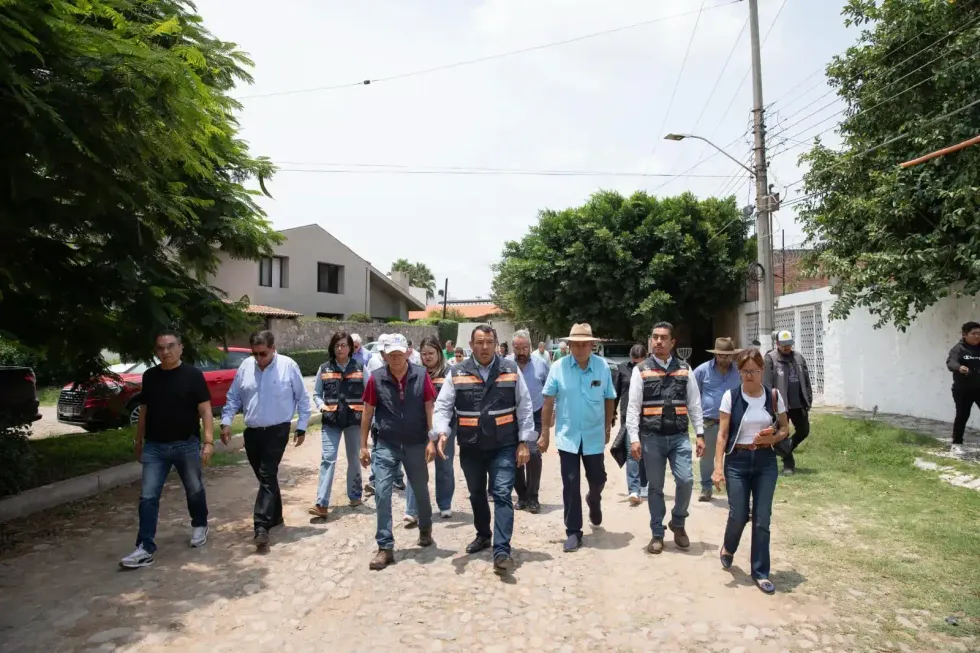 Roberto Cabrera Valencia camina con funcionarios y vecinos por una calle en obras
