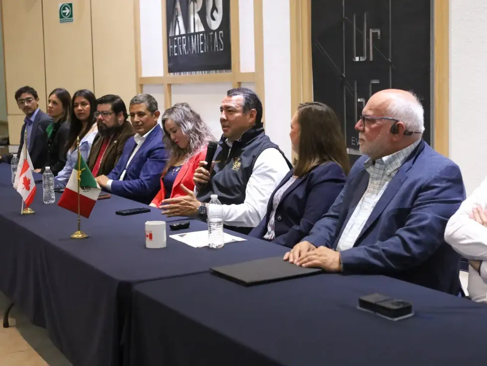 Roberto Cabrera Valencia, con chaleco de la Presidencia municipal, habla ante el panel de la rueda de prensa junto a otros participantes.