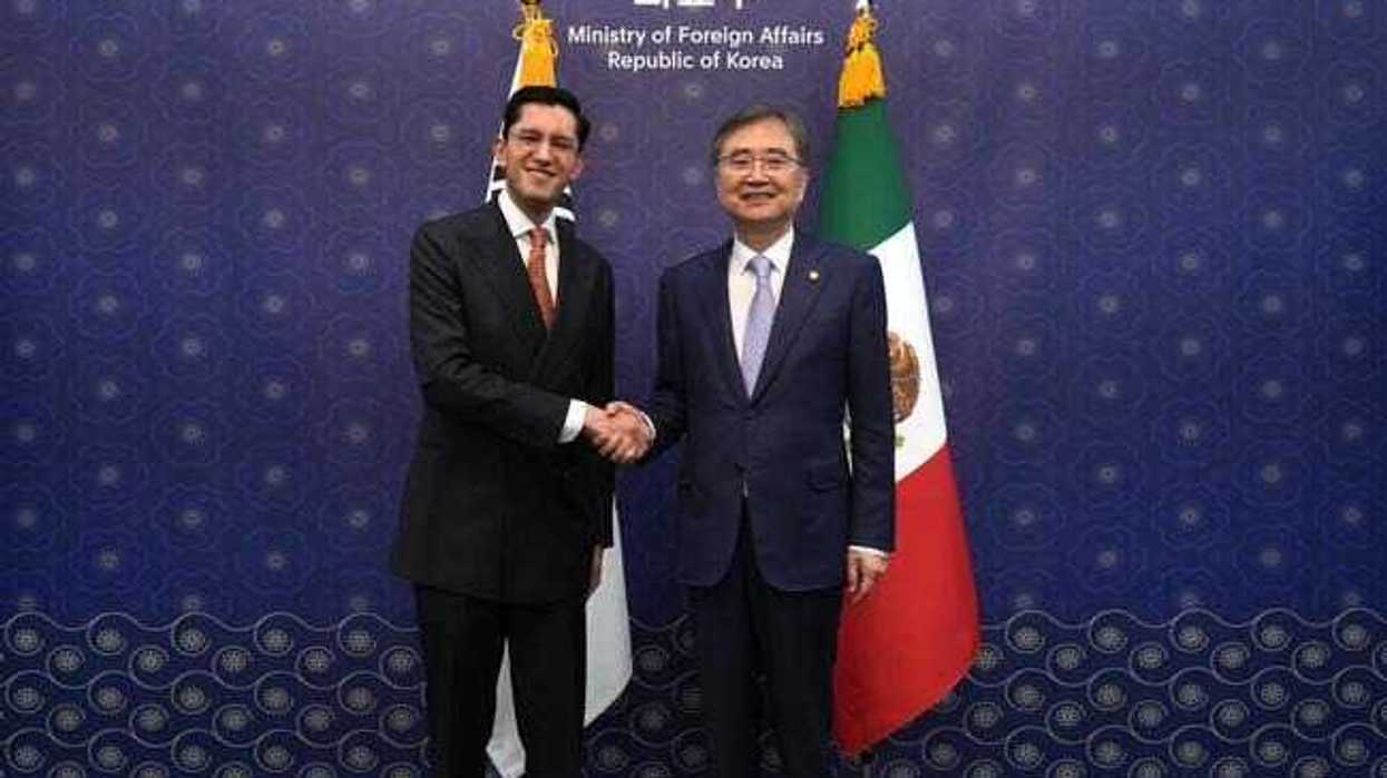 Roberto Velasco Álvarez y Cho Hyun se dan la mano frente a las banderas de México y Corea del Sur en la cancillería coreana