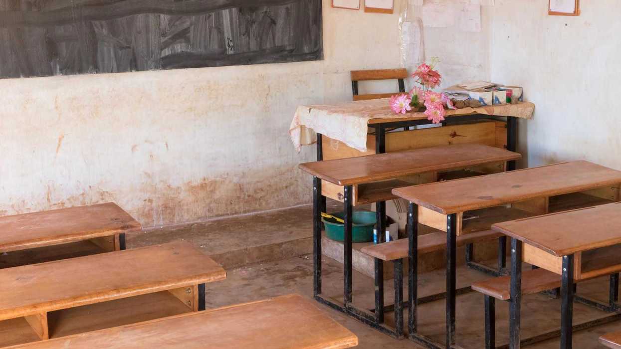 Salón de clases vacío con bancas de madera y pizarrón al fondo, imagen ilustrativa sobre regulación del uso de celulares en escuelas bajo la Ley Kuri en Querétaro.