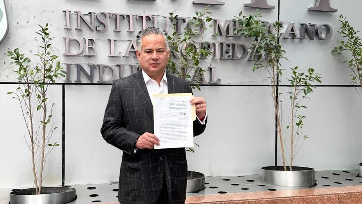 Santiago Nieto Castillo sostiene el escrito de su solicitud frente a la fachada del Instituto Mexicano de la Propiedad Industrial para que investigue espectaculares con el logotipo del Gobierno de México