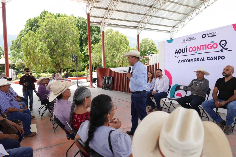 Secretario Anaya Aguilar estrecha mano de productora mientras entrega oficio bajo techo en evento Sierra Gorda