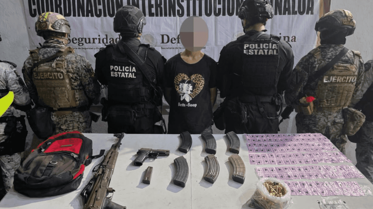 Sedán blanco estacionado frente a una lona con los logotipos de dependencias de seguridad, asegurado tras la detención de un hombre en Culiacán, Sinaloa.