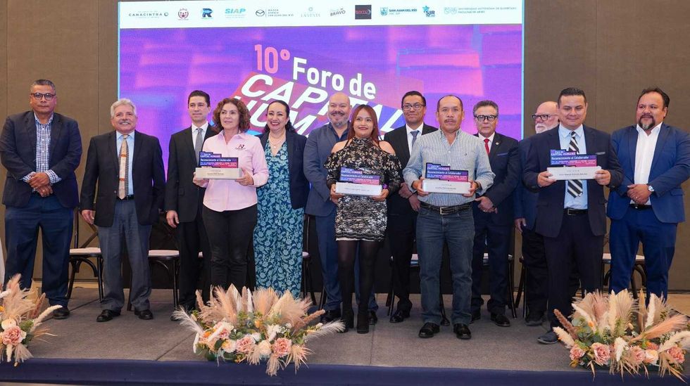 Segundo grupo de colaboradores reconocidos sostiene sus placas durante la ceremonia del foro.