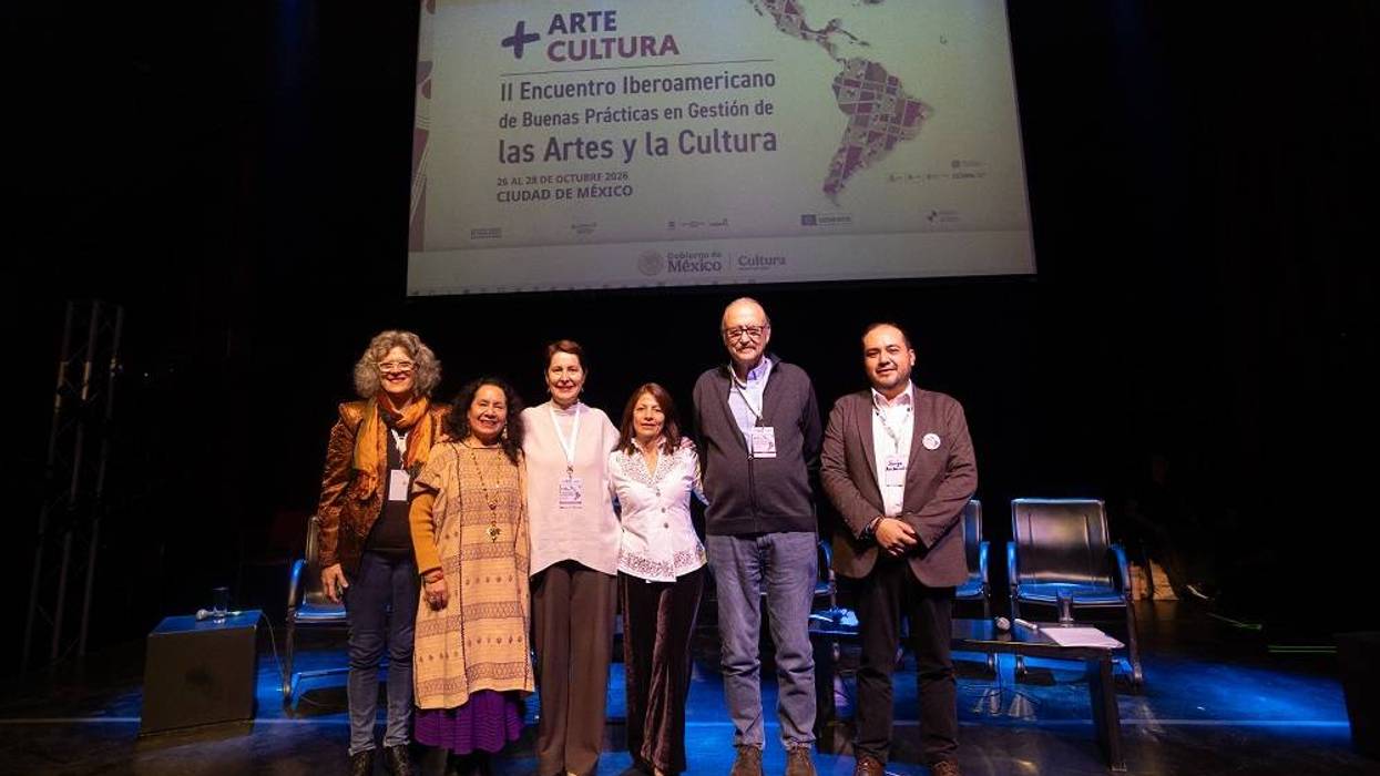 Seis personas posan en el escenario bajo la pantalla del encuentro iberoamericano de gestión cultural en la Ciudad de México