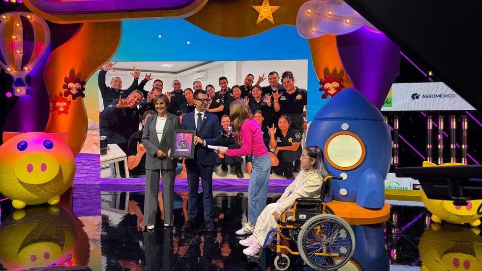 Seis personas posan en un foro con la medalla Rinc\u00f3n Gallardo-Telet\u00f3n enmarcada y una placa de reconocimiento.