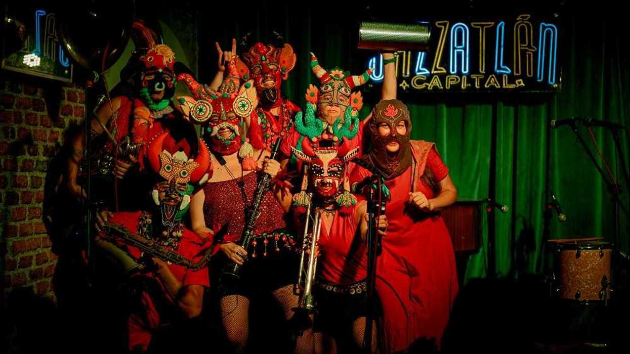 Siluetas de un venado y otros animales en una pantalla de teatro de sombras sobre la arena, en el festival Lu’um Puksi’ik’al