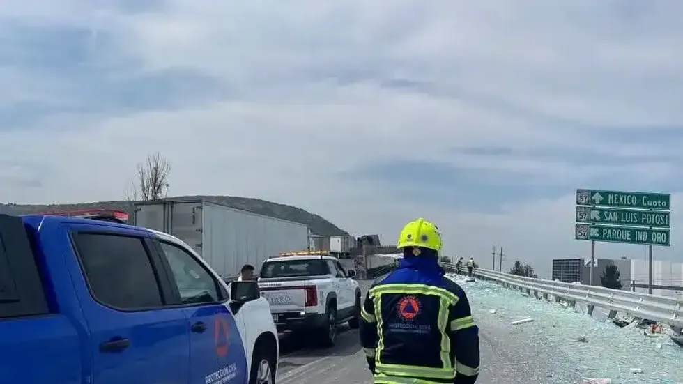 Socorrista de Protecci\u00f3n Civil del municipio de Quer\u00e9taro observa el tractocami\u00f3n volcado y los cristales derramados en el distribuidor vial de Santa Rosa J\u00e1uregui sobre la autopista 57