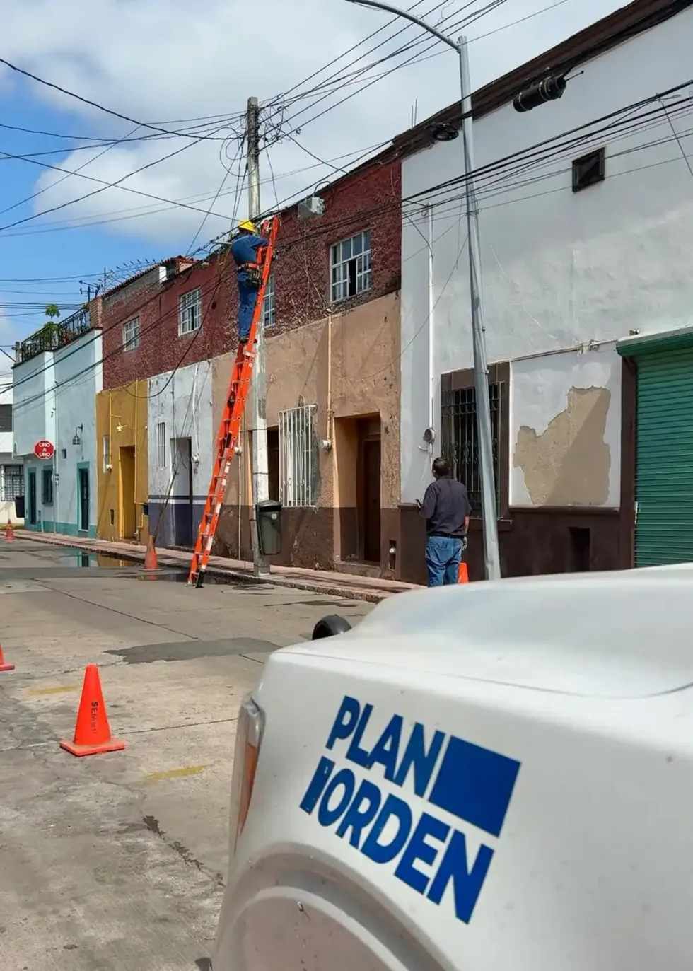 T\u00e9cnico desmonta cableado fuera de servicio desde una escalera para reducir la saturaci\u00f3n de postes en calles de Quer\u00e9taro.