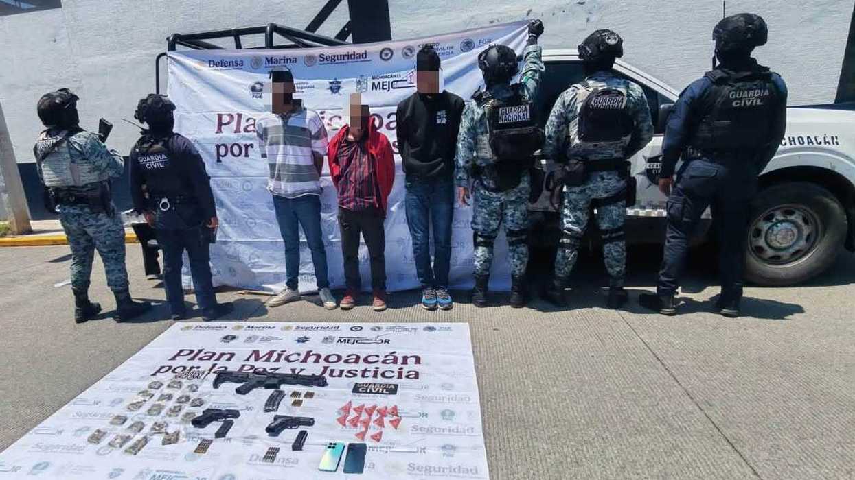 Tablero con fusil, dos pistolas, cartuchos, bolsas con hierba verde, sustancia granulada y teléfonos asegurados por la Guardia Civil y Guardia Nacional en Zamora, Michoacán.