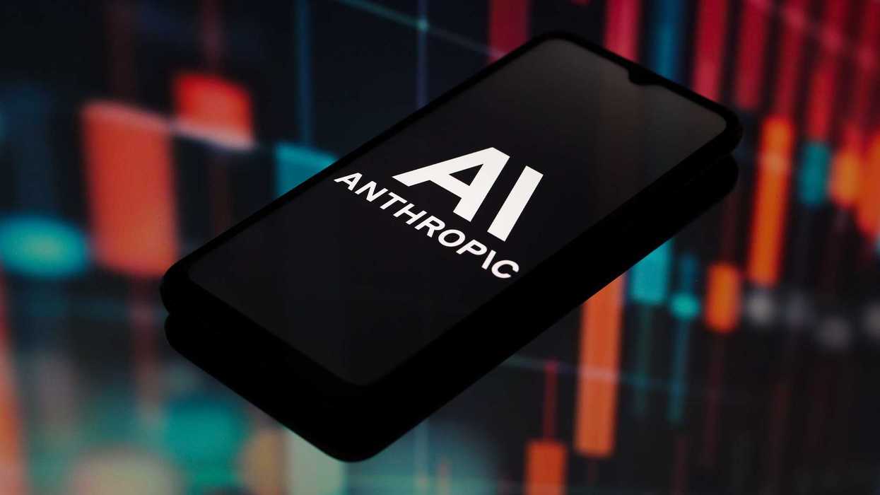 Teléfono con el logotipo de Anthropic en pantalla sobre un fondo borroso de gráficas; Nippan vendió libros a la empresa