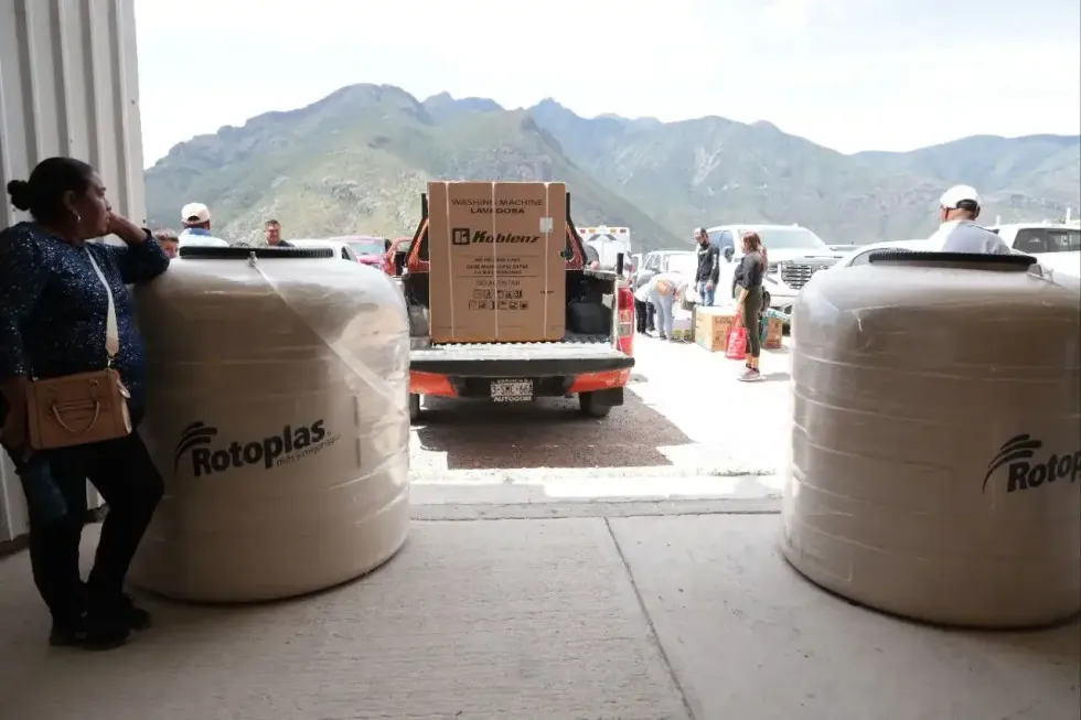 Tinacos y lavadora en camioneta con la sierra de Pe\u00f1amiller al fondo