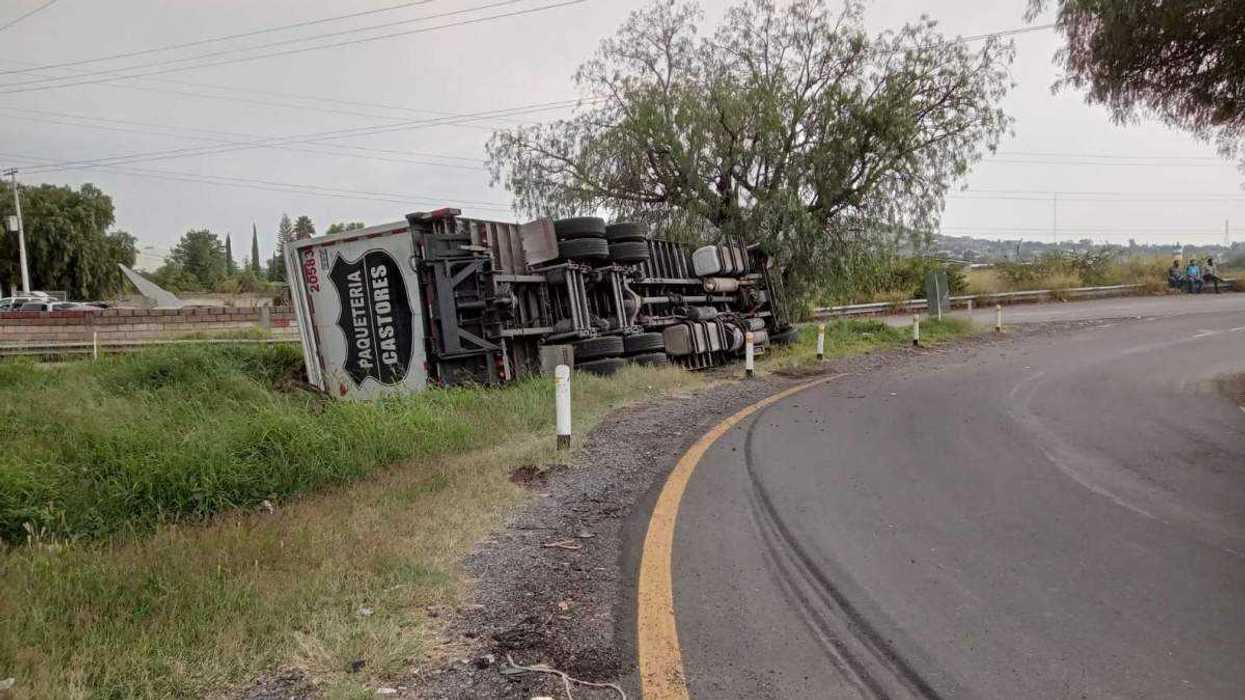 Torton de transportes Castores yace volcado sobre su costado tras impactarse contra pirul en el distribuidor vial del puente La Estancia.