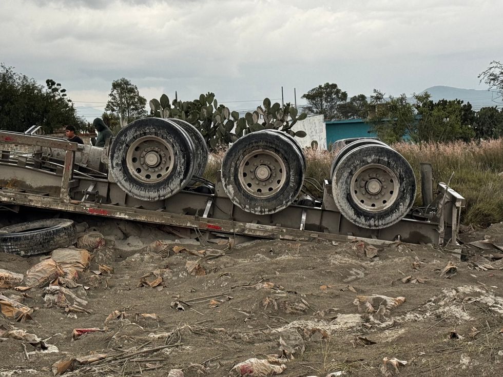 Tr\u00e1iler cargado con cemento volcado sobre la carretera Federal 45, en el acceso a Paso de Mata, donde bomberos realizan labores para rescatar al conductor prensado.