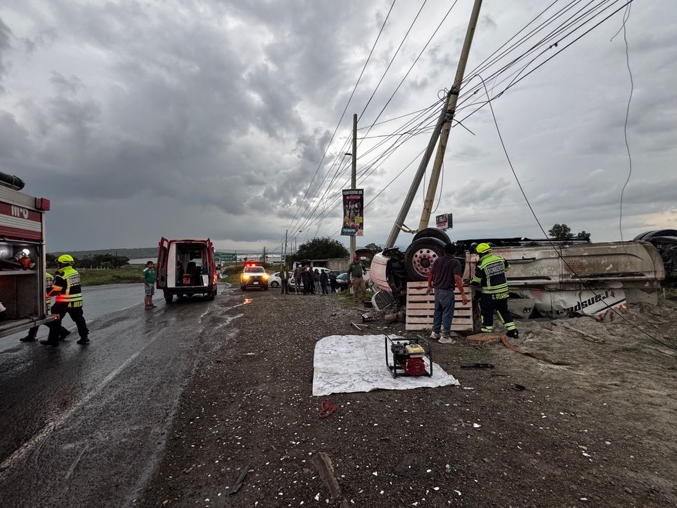 Tr\u00e1iler cargado con cemento volcado sobre la carretera Federal 45, en el acceso a Paso de Mata, donde bomberos realizan labores para rescatar al conductor prensado.