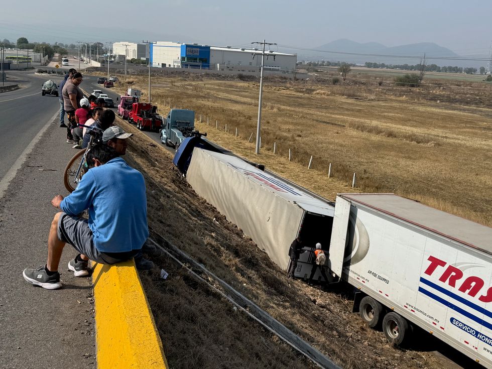 Tr\u00e1iler tipo caja seca volcado sobre el talud del puente en la salida Calamanda de la autopista M\u00e9xico-Quer\u00e9taro en Pedro Escobedo