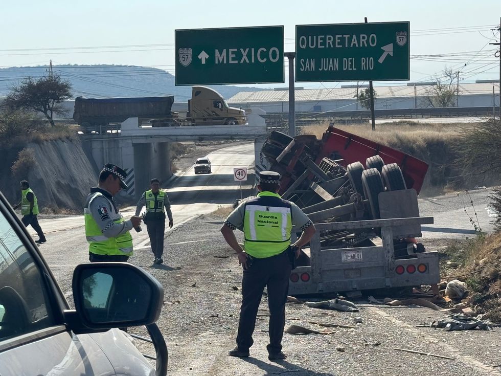 Tr\u00e1iler tipo plataforma volcado con jaulas de pollo en distribuidor vial de la carretera federal 45 rumbo a autopista M\u00e9xico-Quer\u00e9taro