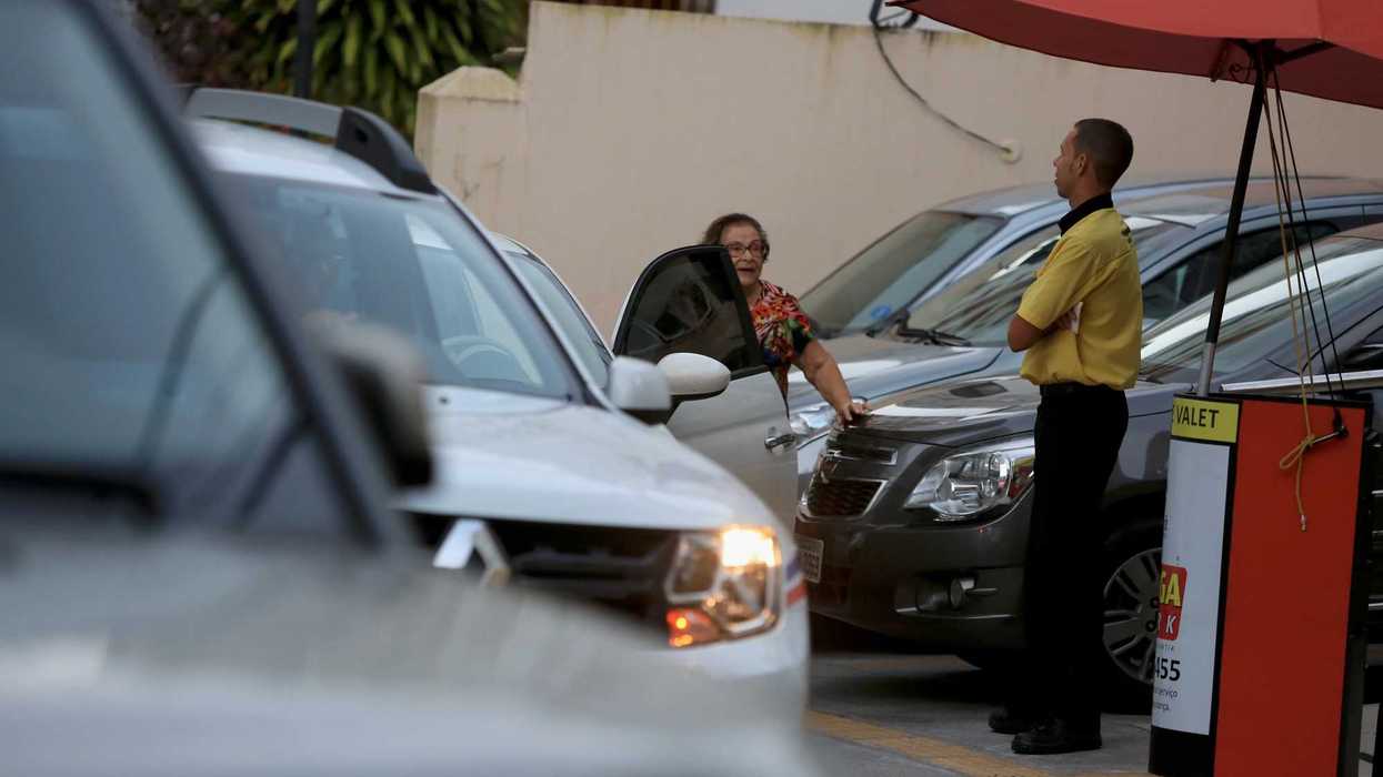 Trabajador de valet parking recibe vehículos en un estacionamiento, servicio sujeto a supervisión y requisitos de operación en Querétaro.