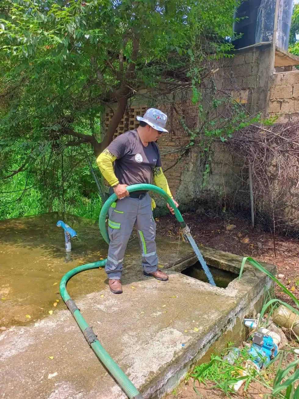 Trabajador descarga agua con una manguera en una cisterna durante un operativo de abastecimiento.