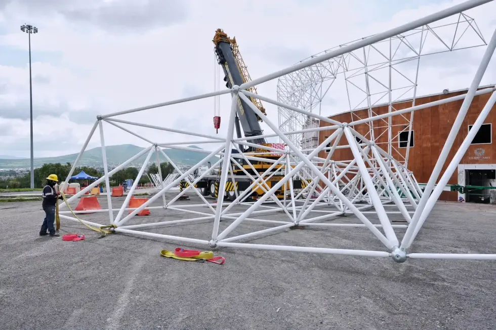Trabajador maniobra estructura met\u00e1lica con gr\u00faa en el Foro Quer\u00e9taro