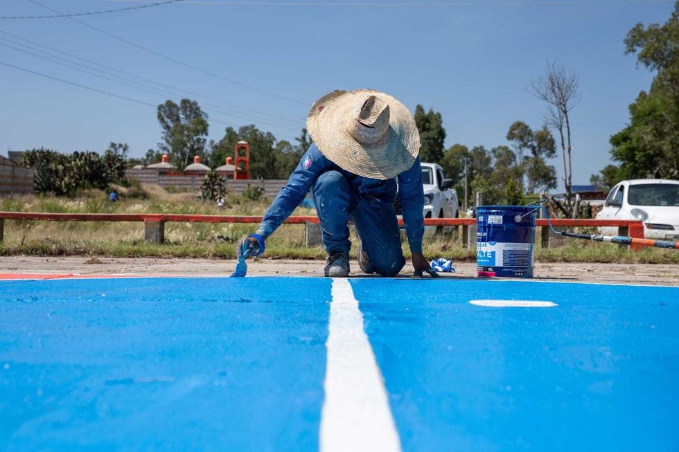 Trabajador municipal pinta cancha deportiva en Perales como parte de las acciones de obra de la jornada comunitaria de San Juan del R\u00edo