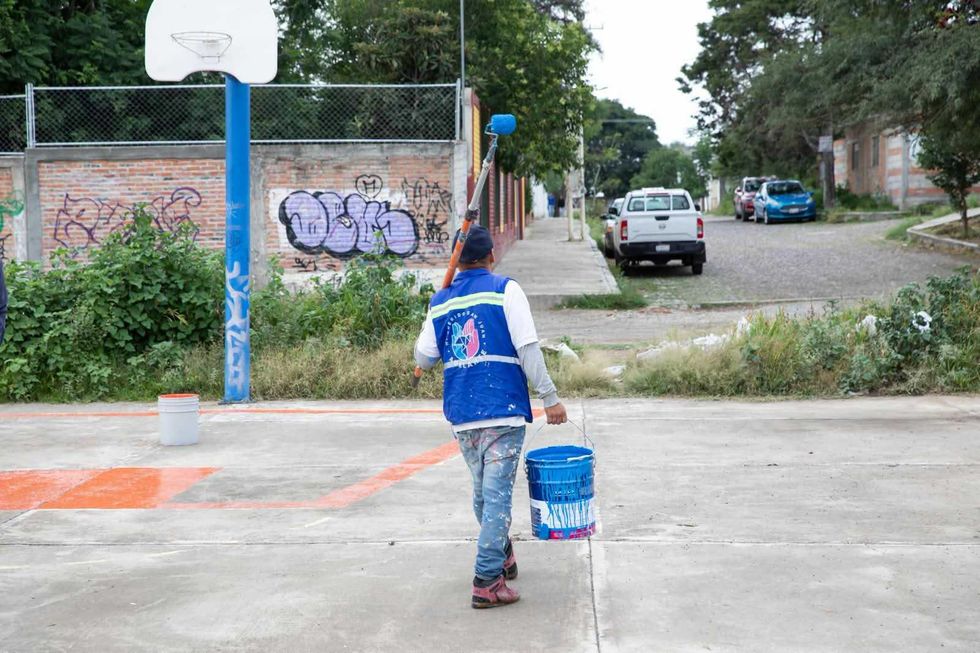 Trabajador municipal pinta espacio p\u00fablico en cancha de basquetbol de Nuevo San Isidro durante jornada comunitaria de San Juan del R\u00edo, agosto 2026