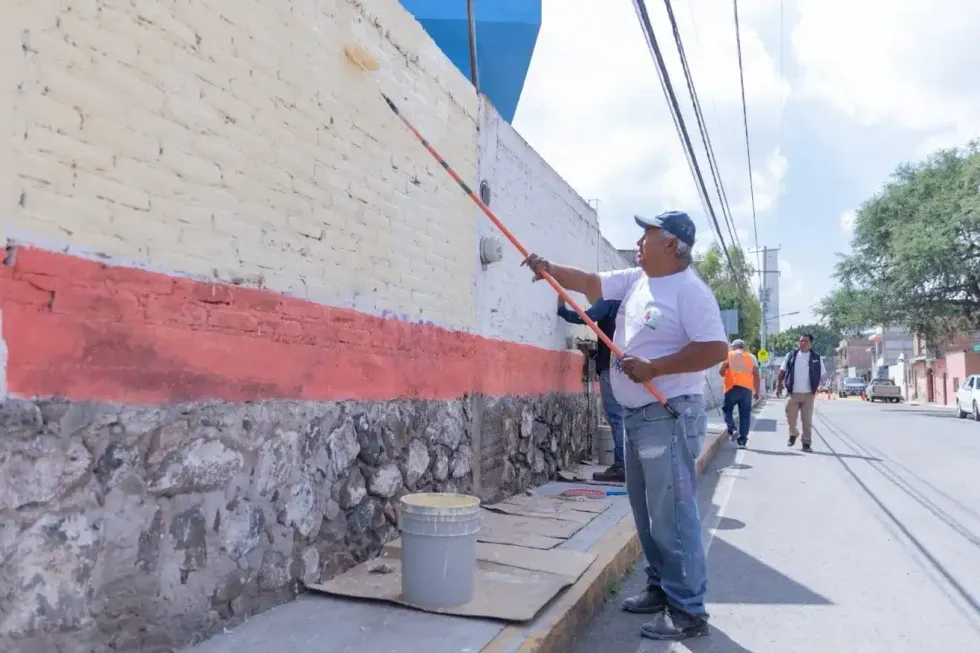 Trabajador pinta una barda durante labores de rehabilitaci\u00f3n en Cerro Gordo, San Juan del R\u00edo.