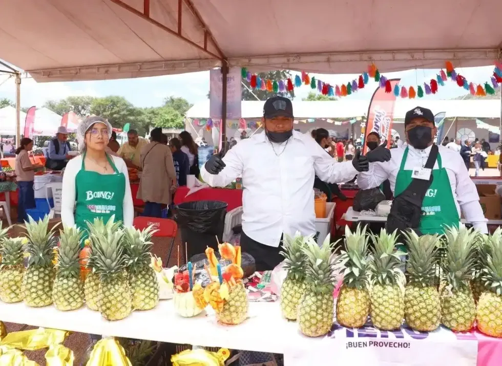 Trabajadores en un stand de pi\u00f1as y bebidas fr\u00edas durante el festival gastron\u00f3mico