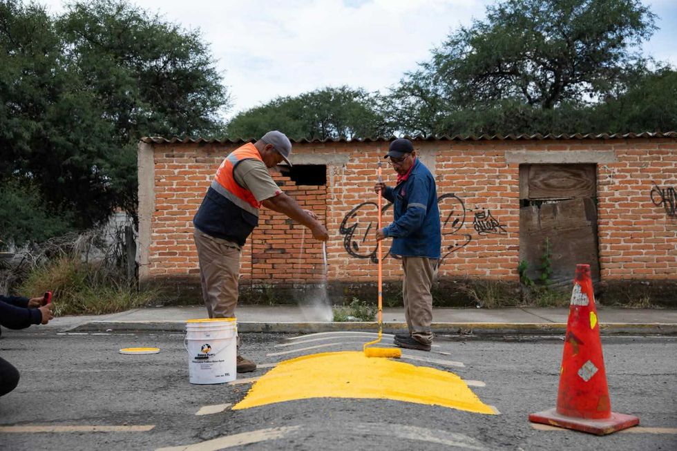 Trabajadores municipales instalan se\u00f1al\u00e9tica de precauci\u00f3n peatonal en Nuevo San Isidro, San Juan del R\u00edo, durante jornada comunitaria de agosto 2026