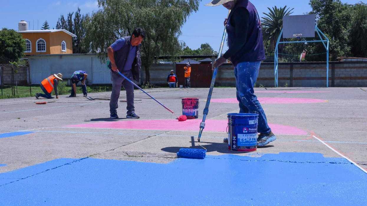 Trabajadores municipales pintan una cancha deportiva en Laguna de Vaquerías.