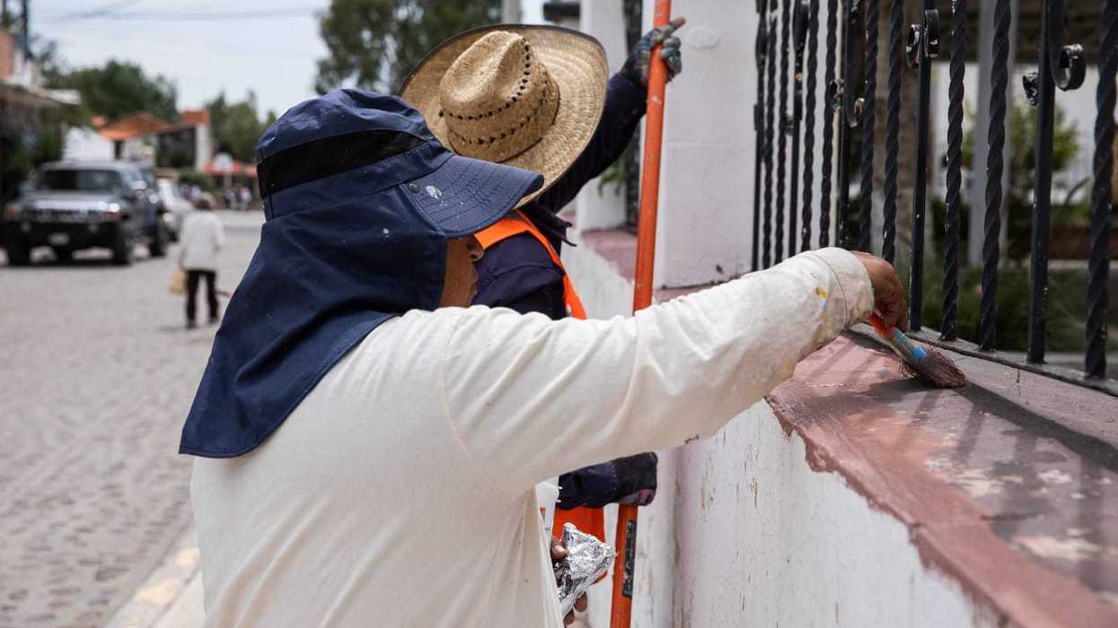 Trabajadores realizan labores de pintura y mantenimiento en un espacio público de la comunidad de Cazadero, San Juan del Río.