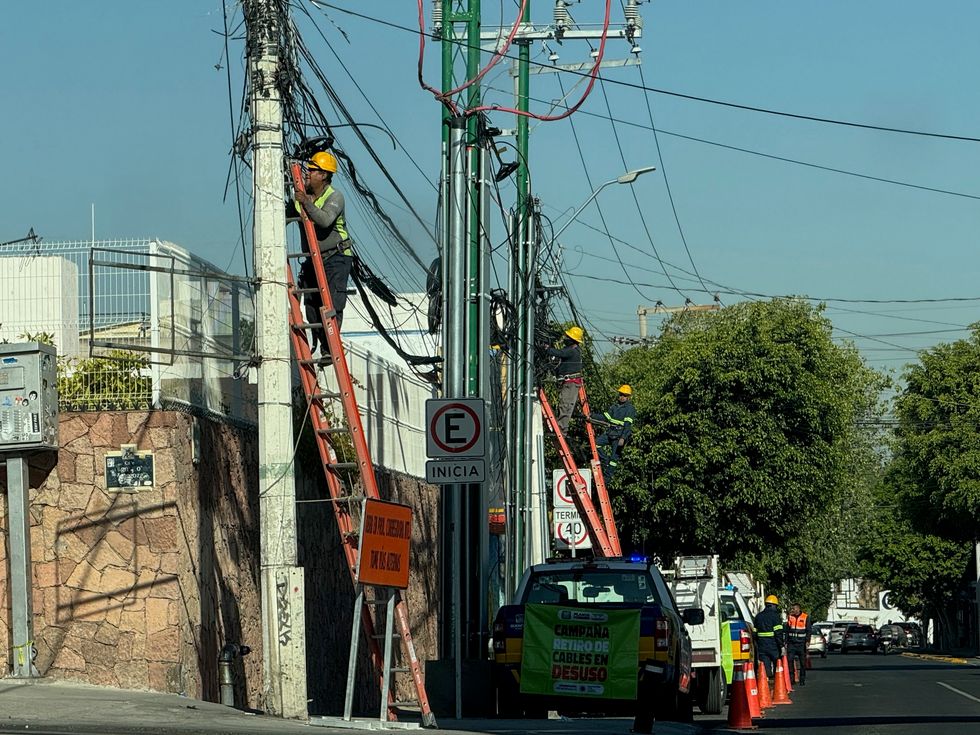 Trabajadores retiran cableado en desuso de postes en vialidad del municipio de Quer\u00e9taro como parte del programa de retiro de cableado en desuso en Quer\u00e9taro