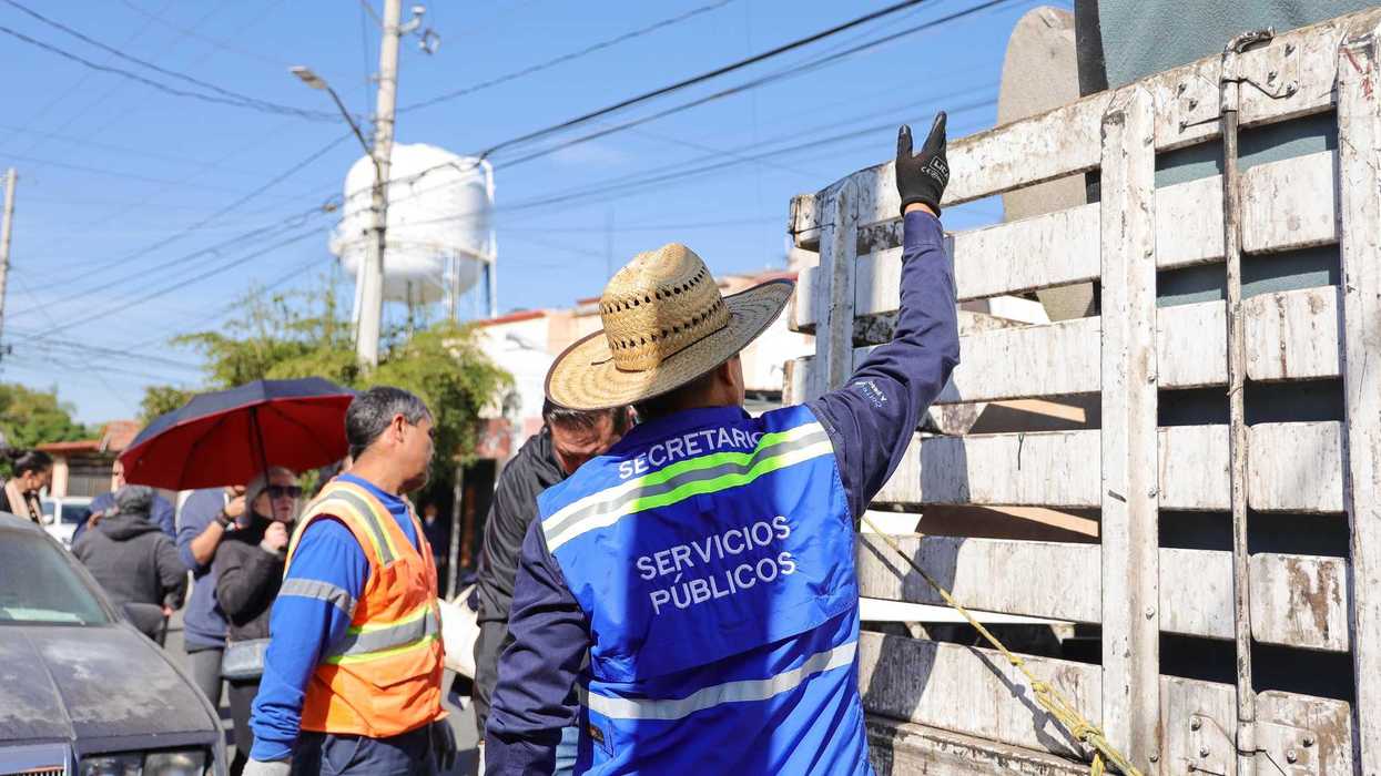 Trabajadores y funcionario cargan objetos en desuso hacia camión de Servicios Públicos durante campaña de tiliches en Corregidora.