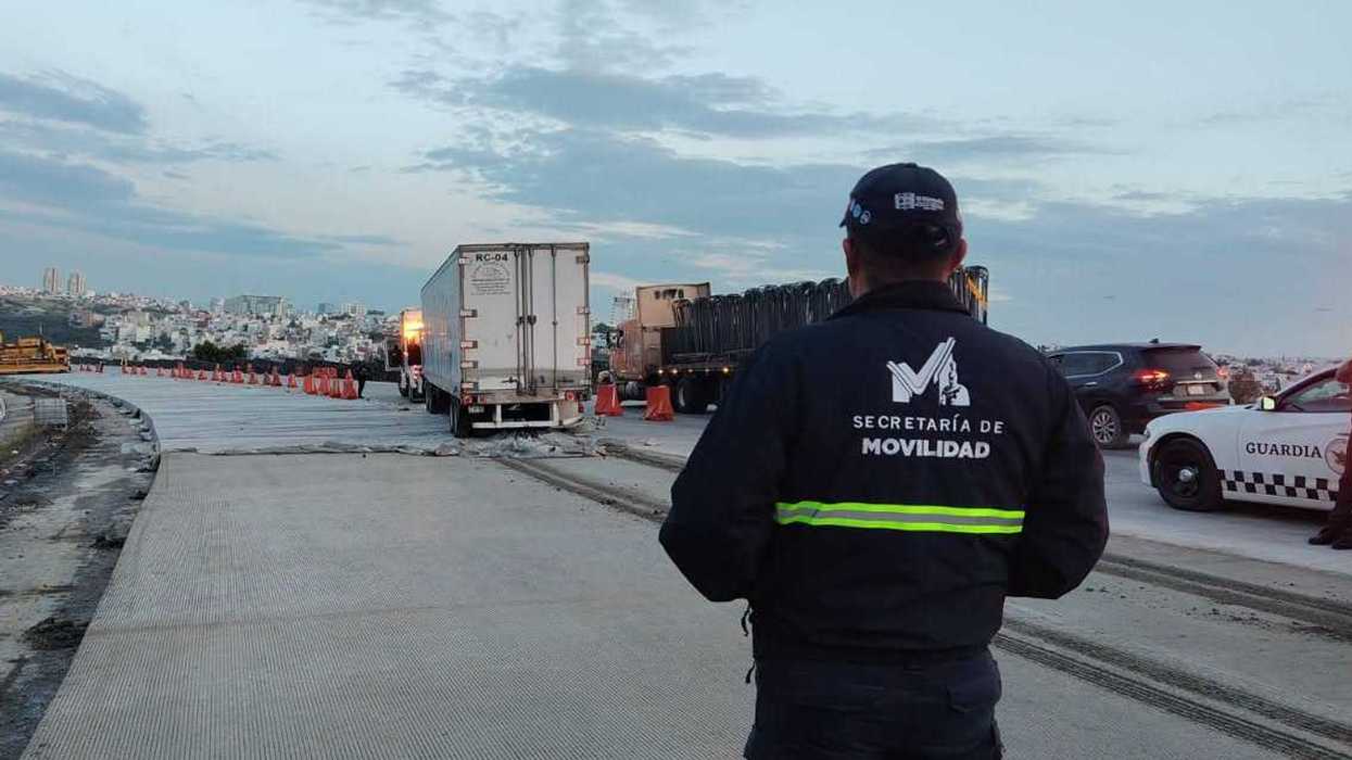 Trabajos de construcción sobre la carretera federal 57, con personal de movilidad supervisando el tránsito