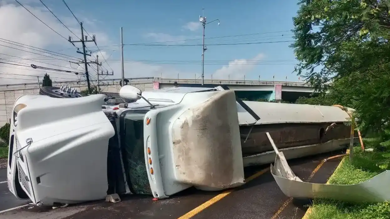 Tractocamión autotanque volcado sobre su costado en la carretera estatal 100, junto a un puente vehicular en Colón.