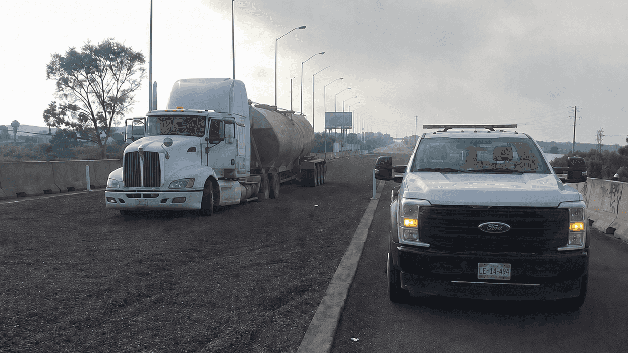 Tractocamión con pipa detenido en el acotamiento de la autopista México-Querétaro junto a camioneta con luces de emergencia