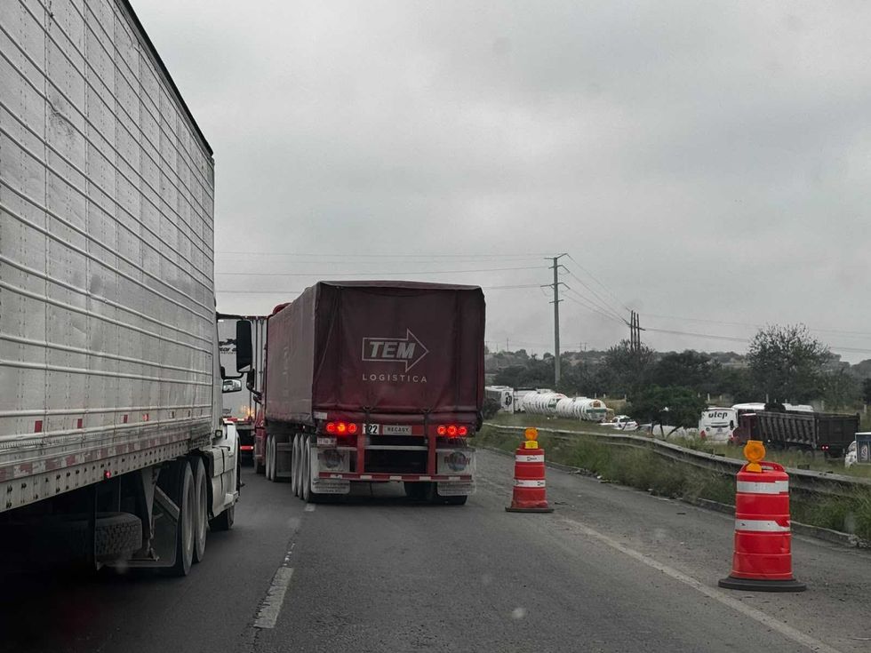 Tractocamiones avanzan por un carril reducido con trafitambos de obra en la autopista M\u00e9xico-Quer\u00e9taro, en la zona de Palmillas.