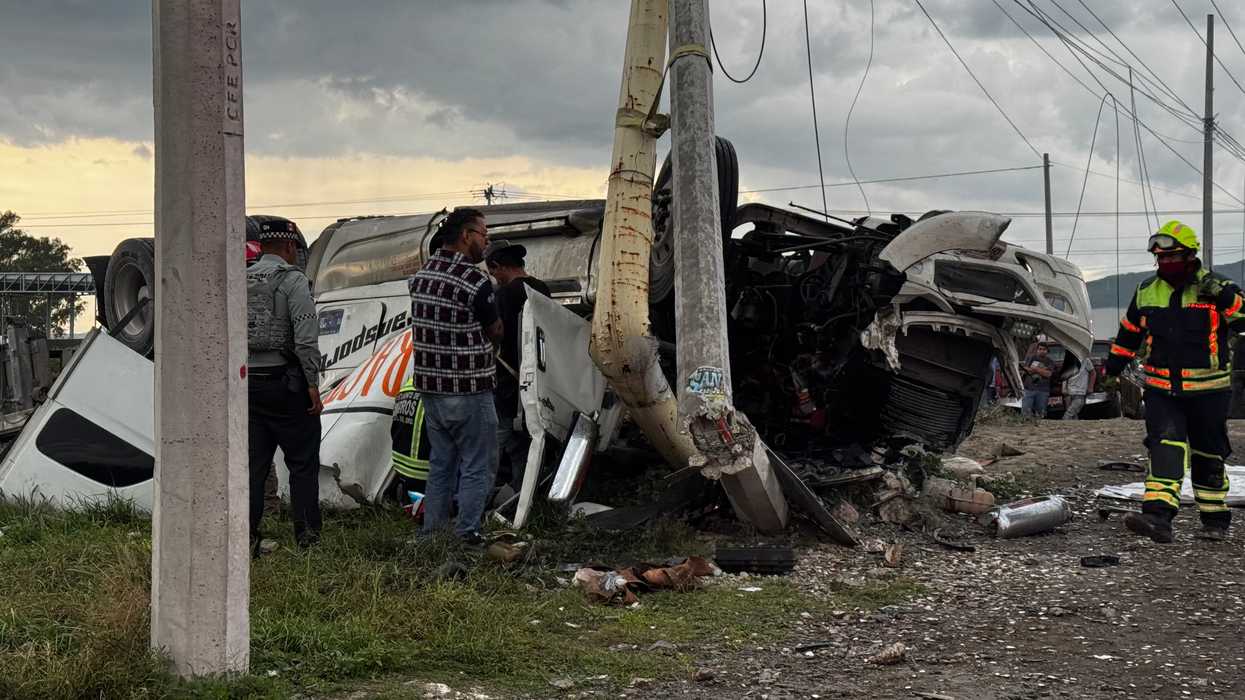 Tráiler cargado con cemento volcado sobre la carretera Federal 45, en el acceso a Paso de Mata, donde bomberos realizan labores para rescatar al conductor prensado.