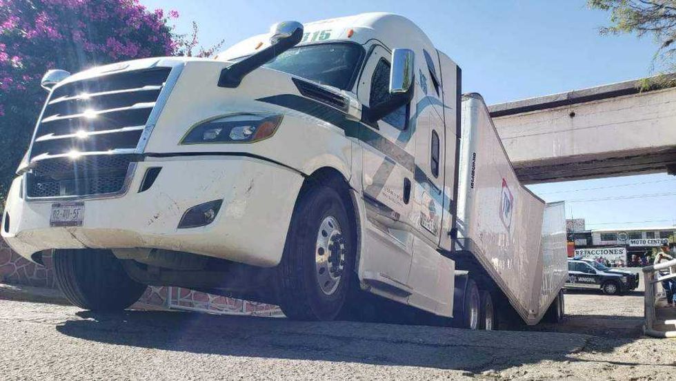 Tráiler de carga tipo caja seca atascado bajo puente San Francisco en San Juan del Río Querétaro.