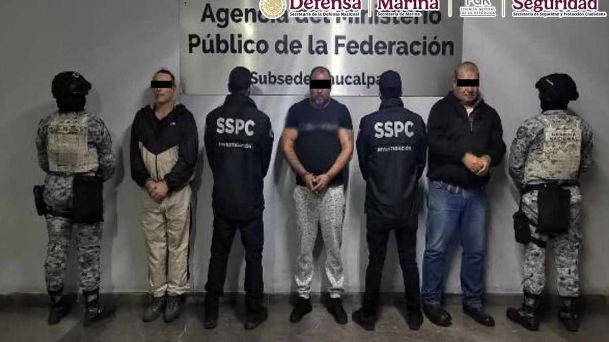 Tres detenidos con el rostro cubierto, entre elementos de la Guardia Nacional y de la SSPC, tras el cateo en Huixquilucan.