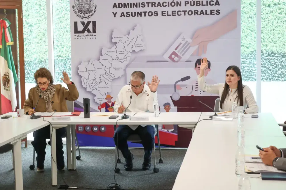 Tres legisladores levantan la mano durante la votaci\u00f3n en la mesa de la comisi\u00f3n