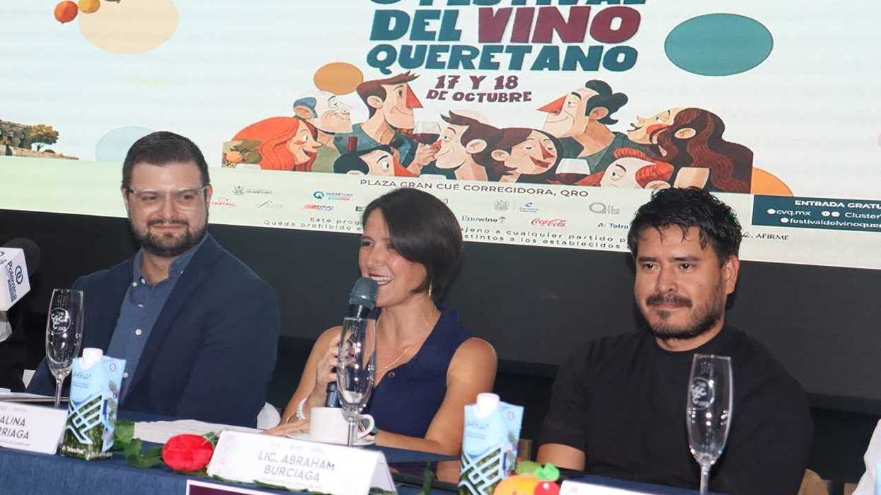 Tres participantes sentados a la mesa de la presentación del Festival del Vino Queretano 2026; una mujer habla con micrófono frente a la pantalla del cartel.