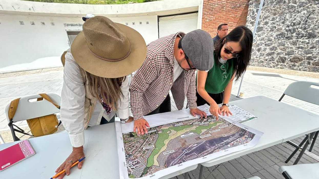 Tres personas revisan un mapa impreso durante una mesa de trabajo del taller de Programas de Manejo de ANP en Querétaro
