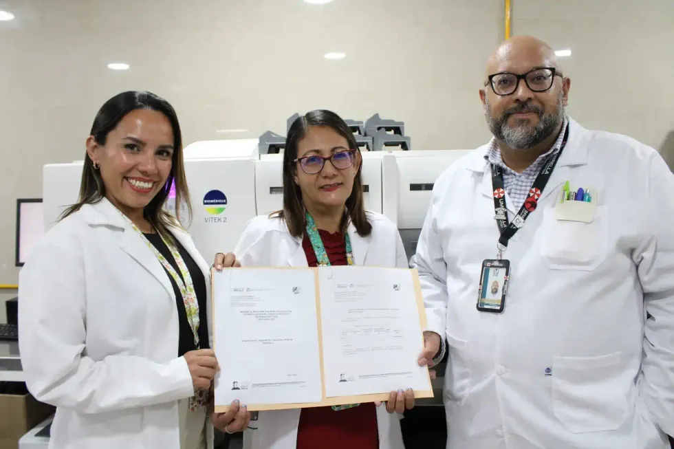 Tres profesionales del laboratorio del HGR No. 1 del IMSS en Quer\u00e9taro muestran los documentos del reconocimiento nacional en bacteriolog\u00eda frente al sistema VITEK 2 de diagn\u00f3stico microbiol\u00f3gico